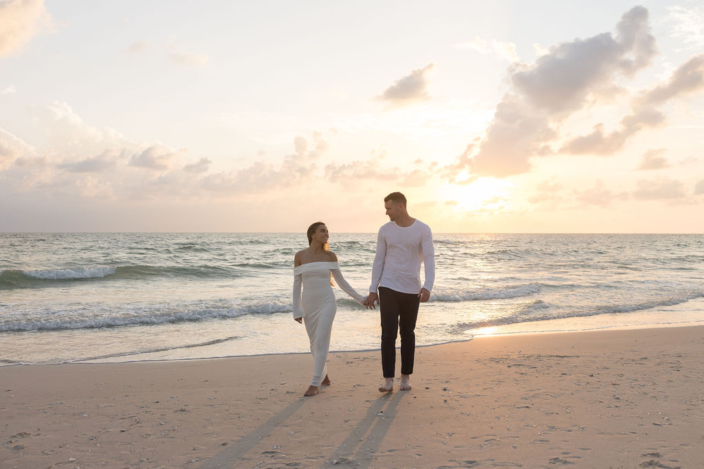 Soft neutral outfits for beach engagement photos on the Naples Pier at sunset