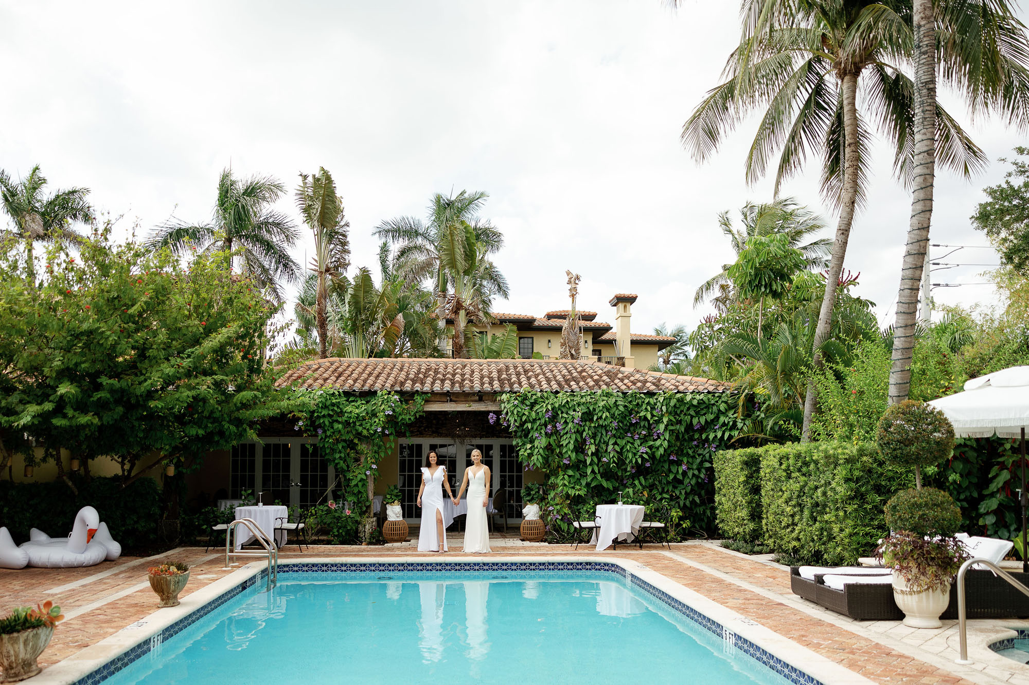 Brides standing in front of pool at the Escalante for romantic couple portraits at Naples FL wedding venues by Veronica Costa Photography