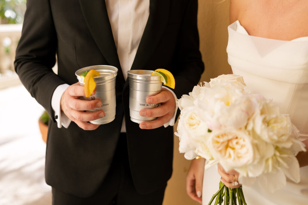 Groom holding drinks and bride with bouquet at Ritz Carlton Naples wedding reception by Veronica Costa Photography