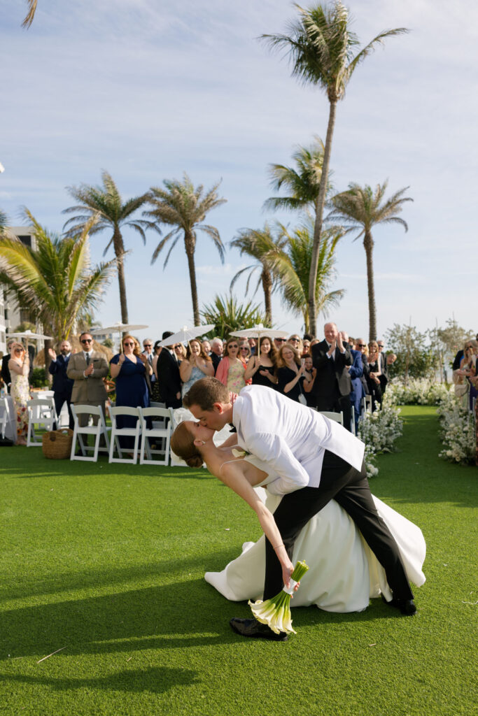 Bride and groom kissing after wedding ceremony at LaPlaya beach resort in Naples.