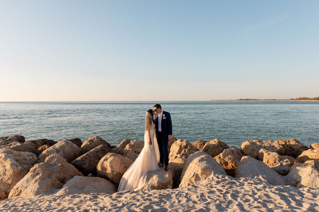 Couple standing on beach in front of ocean at a Naples Florida beach wedding venue, South Seas Island Resort. 